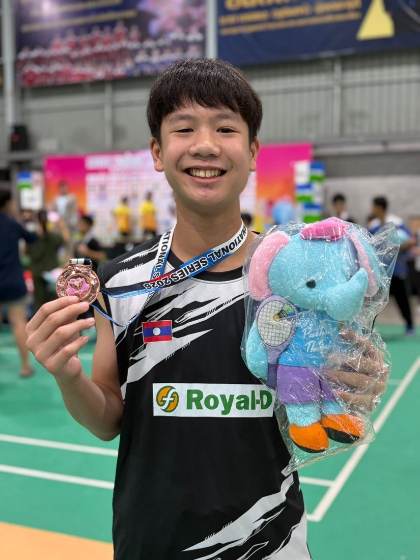 Bounthavy Sayarath holding a medal with the Lao flag on his shirt